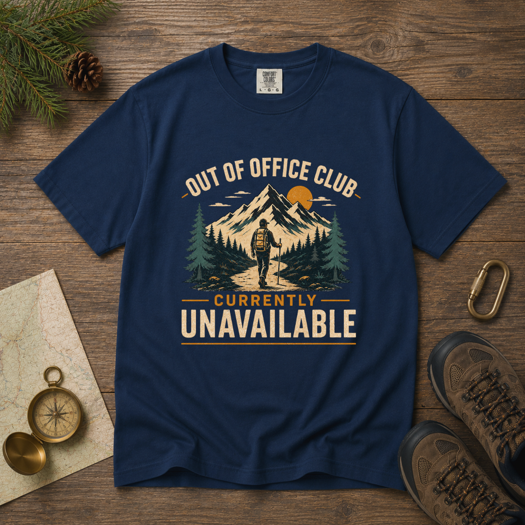 Navy blue t-shirt with outdoor graphic and text on a wooden surface with hiking accessories.