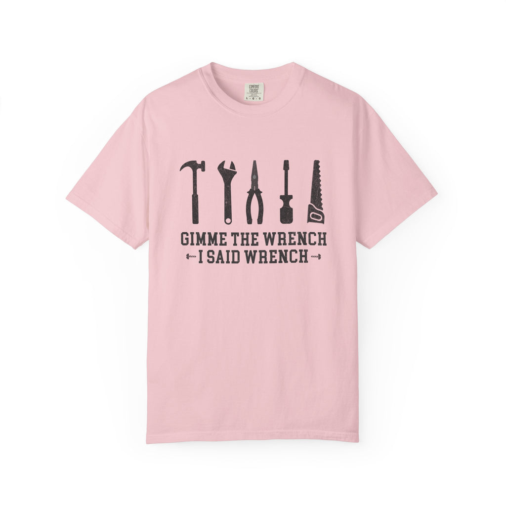 A light pink short-sleeve crewneck t-shirt with a black graphic print on the front showing various hand tools and the text 'GIMME THE WRENCH I SAID WRENCH'.