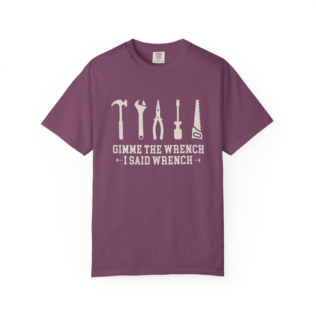 A purple short-sleeve crewneck t-shirt with a white graphic of various hand tools and the text 'GIMME THE WRENCH I SAID WRENCH' printed on the chest, displayed on a clean white background.