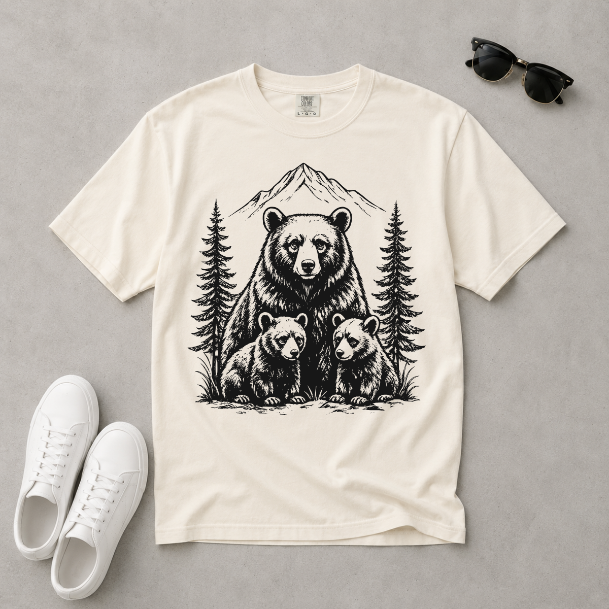 White t-shirt with bear and cubs design on a gray background, paired with white sneakers and sunglasses.